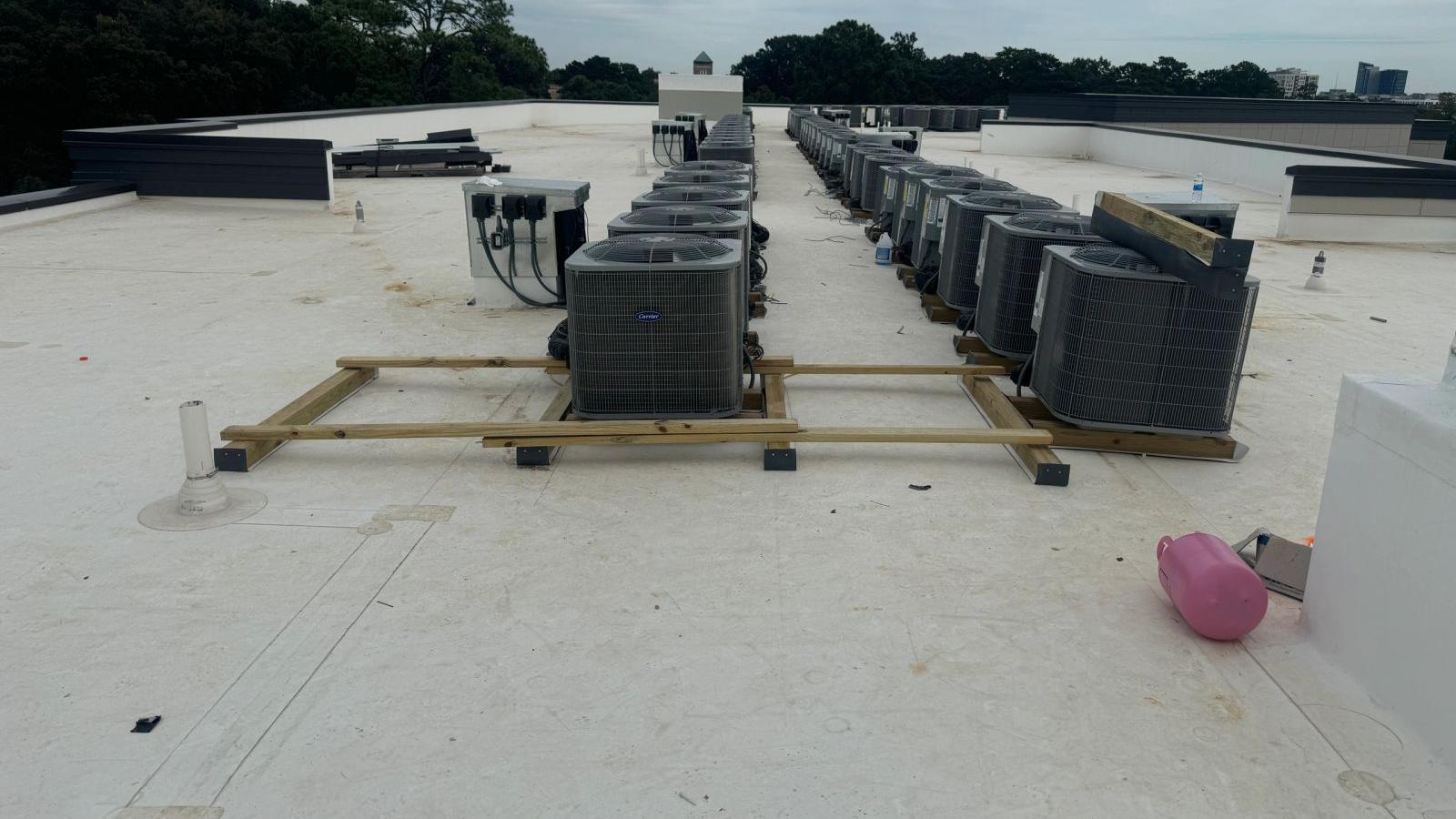 Rows of rooftop condensing units installed by our crew on an apartment building
