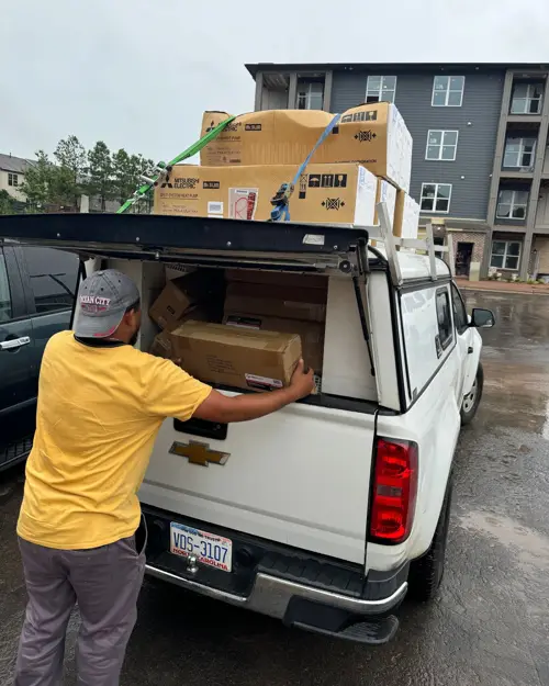 Crew loading equipment into a company truck at an apartment site